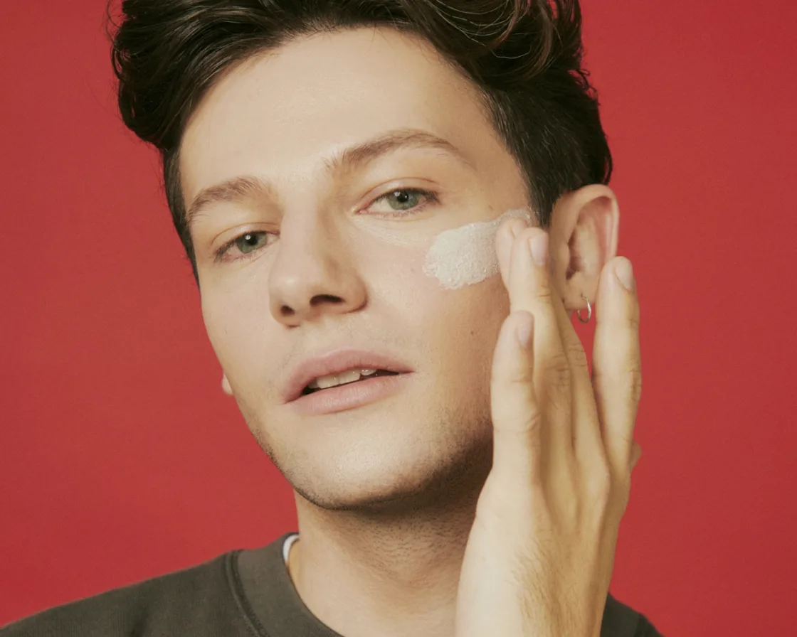 Content creator filming a beauty product with a camera.