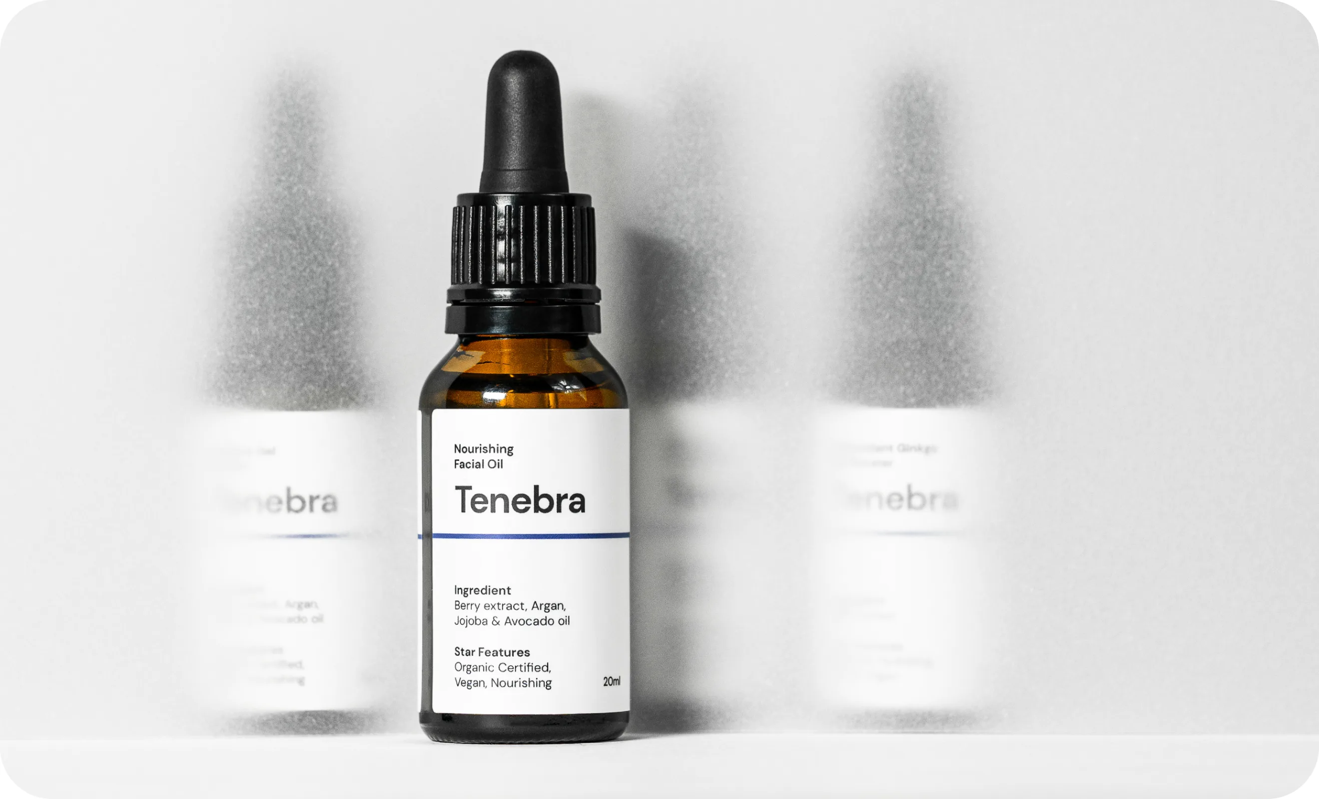 Amber dropper bottle of Tenebra Nourishing Facial Oil displayed on a shelf with ingredient and certification icons