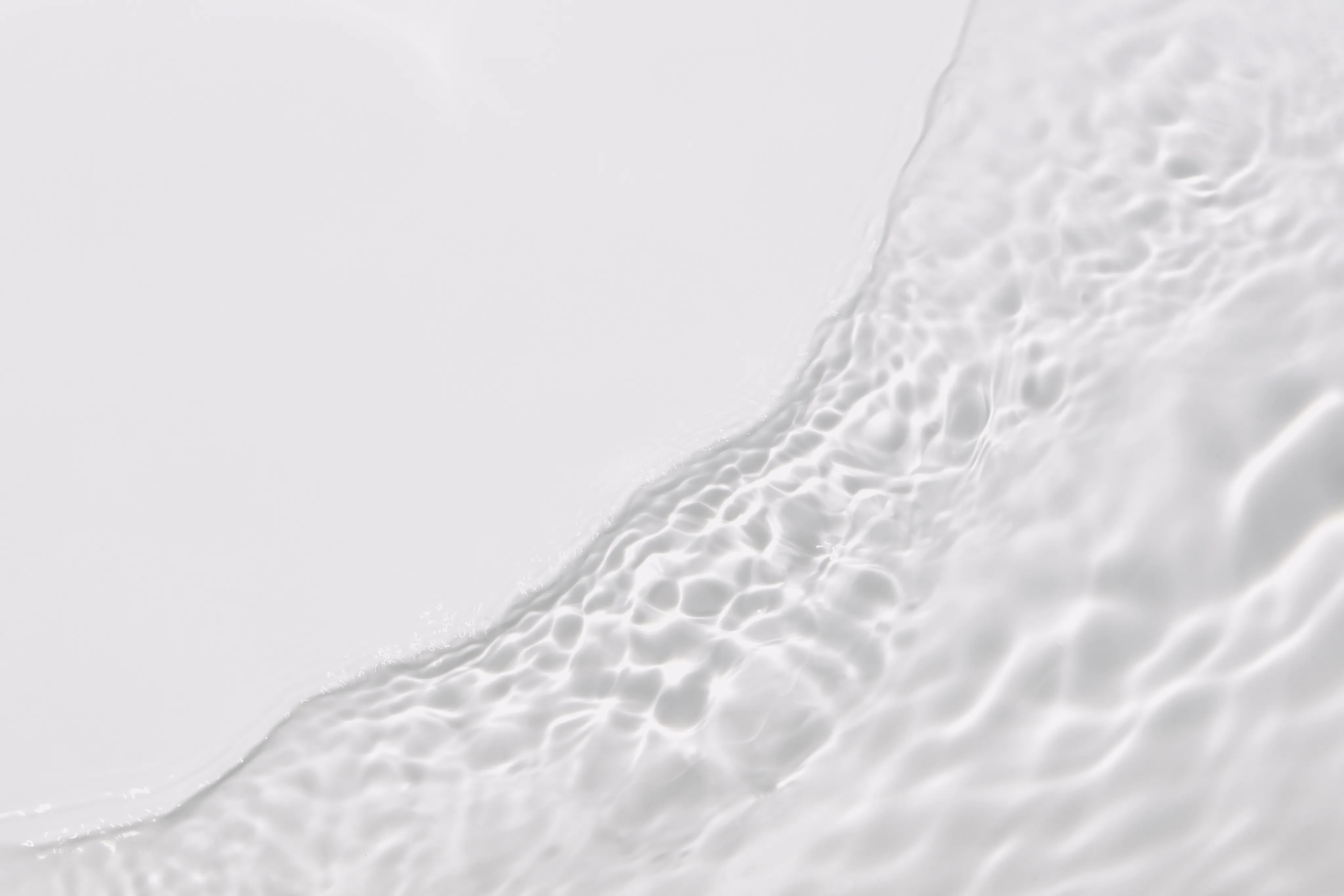 Close-up of rippling cream or water texture with soft light reflections