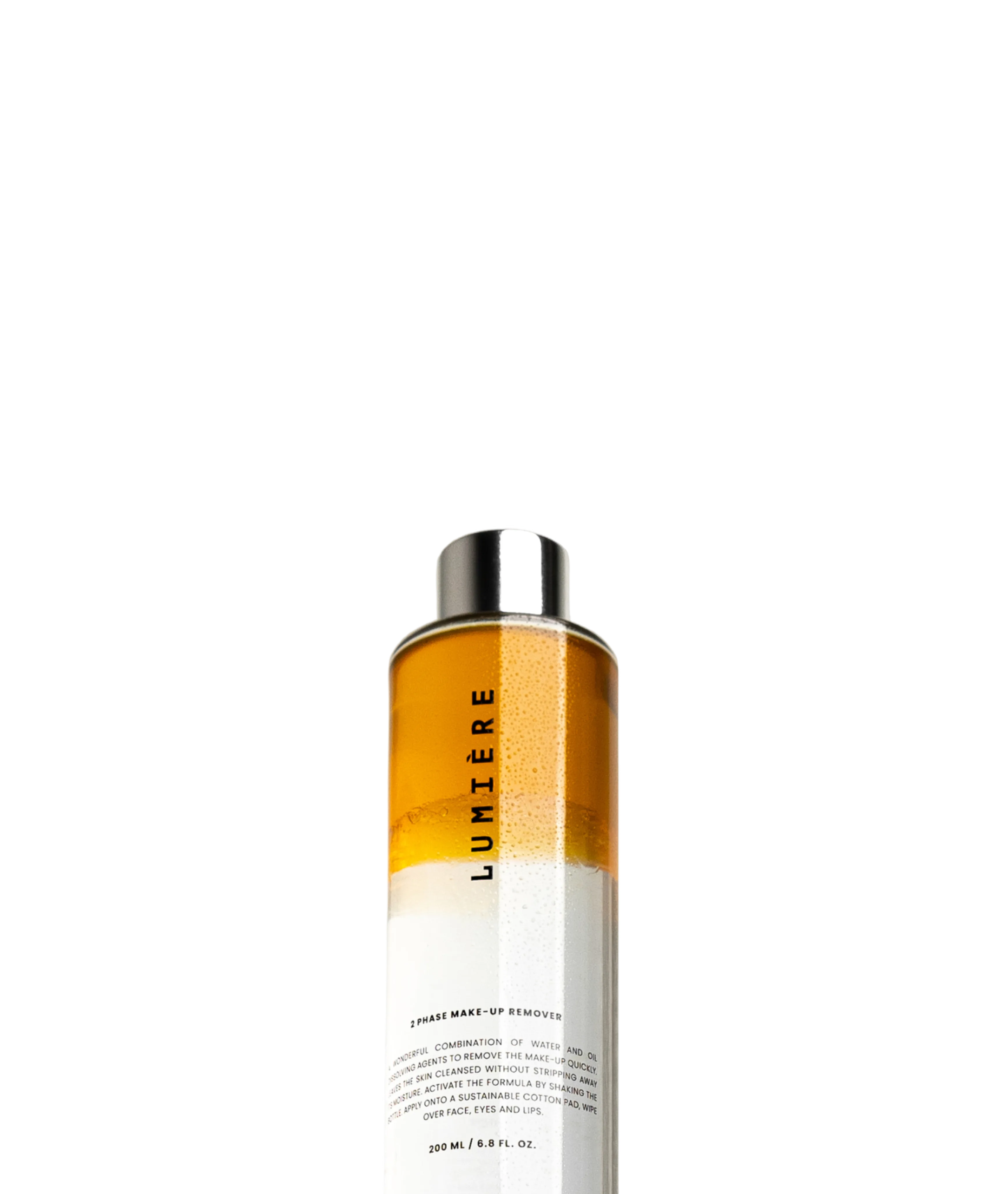 Amber glass bottle labeled "LUMIÈRE" cream make-up remover, shot straight-on against a light grey background