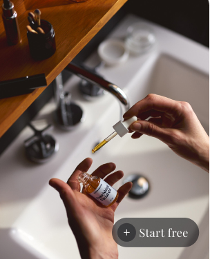 A person holding a bottle of facial oil